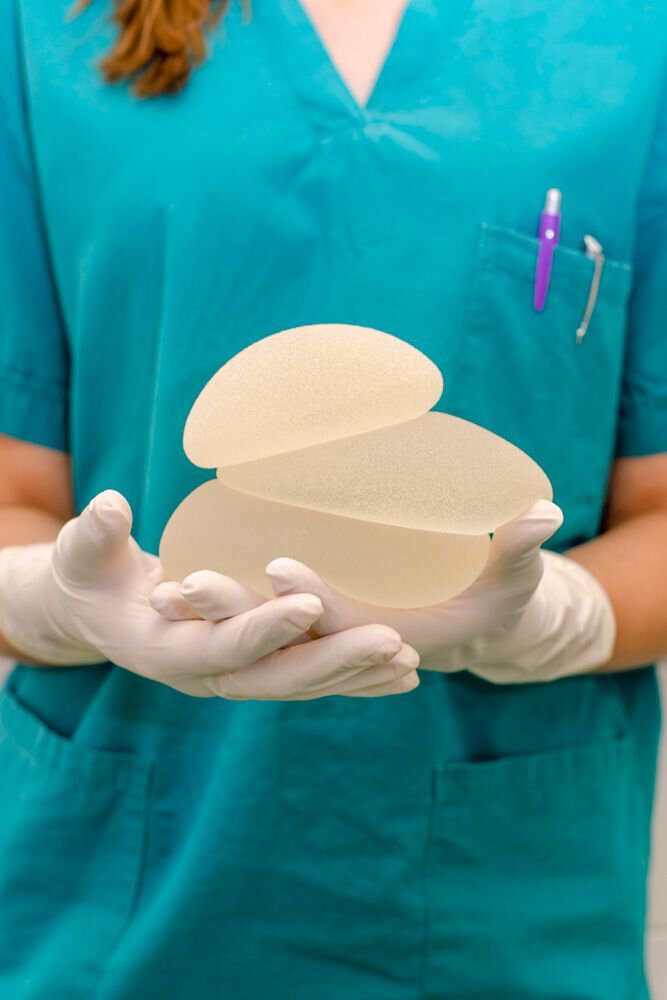 A plastic surgeon holding breast implants